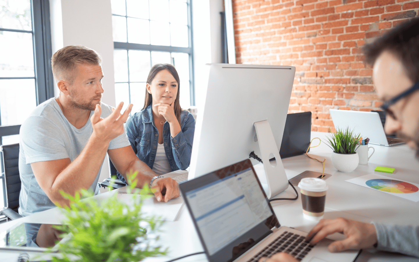 Two people discussing the key elements for website redesign in front of monitor