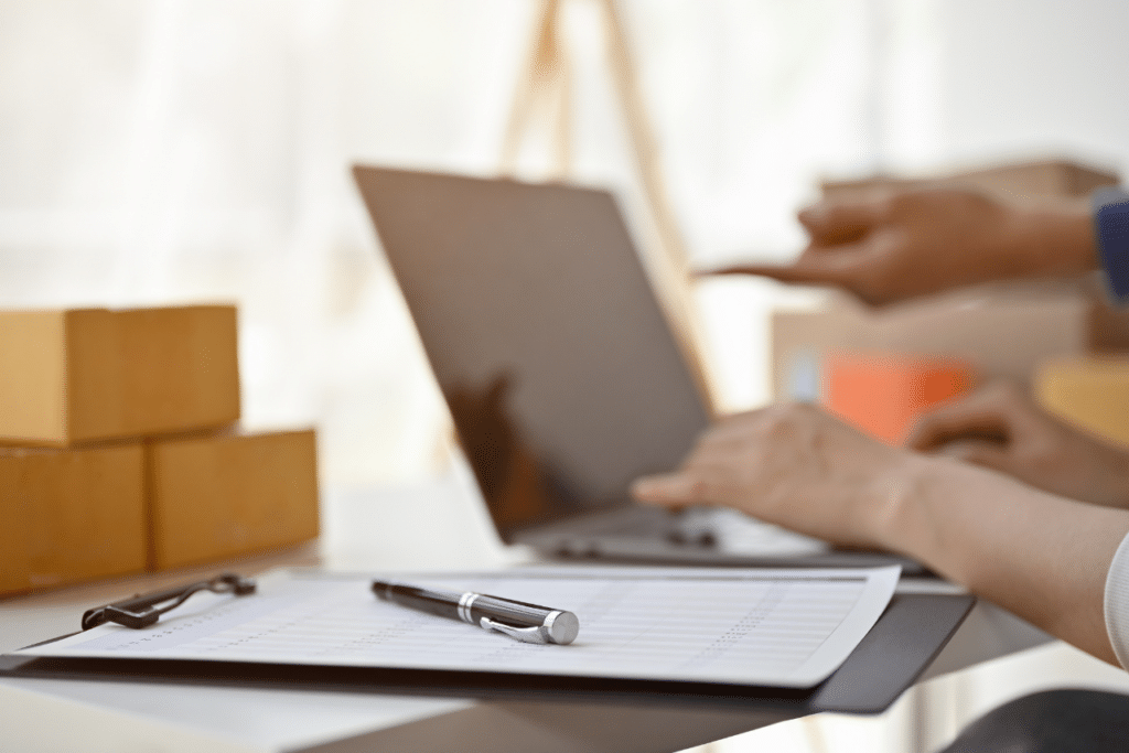 A computer with a person building a website marketing plan with notebook